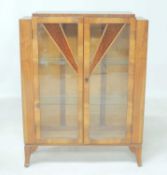 ART DECO WALNUT DISPLAY CABINET, c. 1935, doors inset with amber sunburst panels opening to two