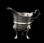 GEORGE V SILVER TRIPOD MILK JUG, Pairpoint Bros., London 1916, helmet form with cut card rim,