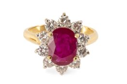 18CT GOLD RUBY & DIAMOND CLUSTER RING, the central oval-cut ruby (10 x 7mms) within border of ten