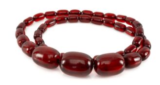 CHERRY BAKELITE BEAD NECKLACE, 42 oval clear beads from 30mm to 15mm wide Provenance: consigned from
