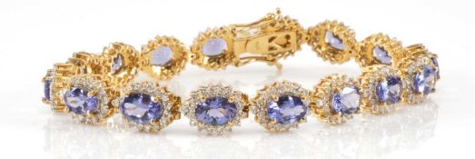 ITALIAN 14K GOLD TANZANITE & DIAMOND BRACELET, the 16 7x5mm, within brilliant cut diamond borders,