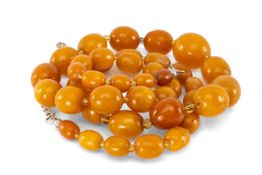 STRING OF BUTTERSCOTCH AMBER BEADS, largest 19 x 17mms, with clear coloured bead spacers throughout,