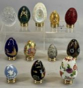 TWELVE COLLECTOR'S EGGS ON STANDS, various materials including cloisonné, porcelain, and glass