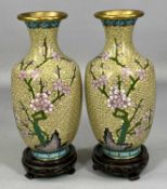 PAIR OF CHINESE CLOISONNÉ VASES, decorated with cherry blossom and birds, on carved wooden stands,