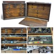TWO VINTAGE OAK TOOL CABINETS, one with folding front enclosing four short and three long drawers,