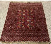 TURKMEN TEKKE RUG, red ground with central elephant foot design, within multiple geometric