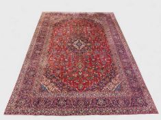 KASHAN MAIN CARPET, central lozenge medallion on a madder field, stepped spandrels, palmette border,