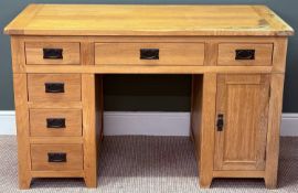 A MODERN LIGHT OAK TYPE DESK having five small drawers, one larger central drawer and a cupboard, 86