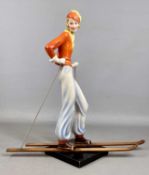 ART DECO POLYCHROME FIGURE, possibly Goebel, female skier wearing orange jacket and hat with