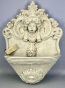 STONEWARE GARDEN WATER FEATURE with cherub's head and scroll moulding, wall mounted, with pump,