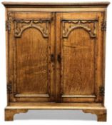 GOTHIC STYLE OAK TWO-DOOR CUPBOARD, having applied moulded decoration to the double doors,