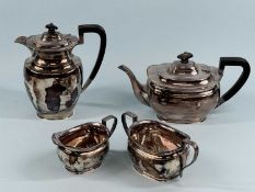 GEORGE V OVAL FOUR-PIECE TEA SERVICE of plain oval form, teapot and hot water jug with ebonised
