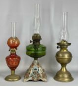 THREE OIL LAMPS, one having painted cast iron base, faceted green glass reservoir, and twin burners,