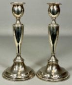 PAIR OF GEORGE V CIRCULAR SILVER CANDLESTICKS with weighted bases, hallmarks rubbed, 23.5cms (h)