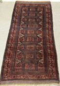 BALUCH RED GROUND RUG, 238 x 106cms Provenance: private collection Gwynedd
