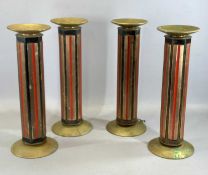 FOUR HEAVY BRASS & METAL CANDLE HOLDERS, with red and black decorated bodies, 47cms (h)