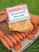 A pallet of plastic fencing and Danger signs