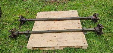 A pair of trailer axles, no wheels