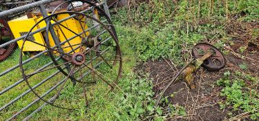 A pair of cast iron implement rear wheels and a small front wheel