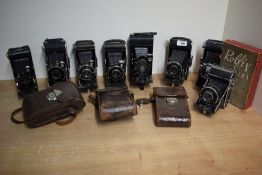 Eight folding cameras. A Thugee, a Voigtlander Jubilar, five Rodenstock, and a boxed Rolfix II