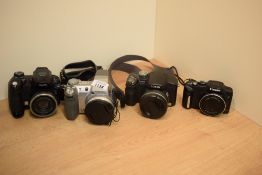 Four Digital cameras. A Canon SX170 IS, a Lumix DMC FZ28, a Fujifilm Fine Pix S5000, and Sony