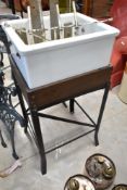 A vintage belfast style sink, with measure/feeder attachment, on bespoke wood and cast stand,