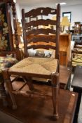A traditional ladder back kitchen chair having rush seat