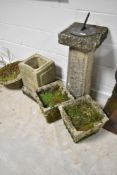 A selection of concrete garden planters and sundial