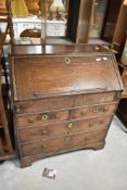 A 19th Century and later oak bureau of small proportions , with interesting design including book