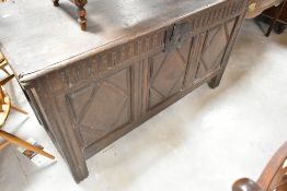 A period oak kist having carved frieze and triple diamond carved panels, width approx. 124cm
