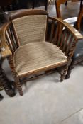 An early 20th Century oak arm chair with rail and twist supports, later upholstery to seat and back