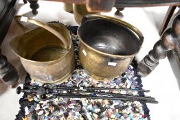 Two brass coal helmets and a selection of fire tools
