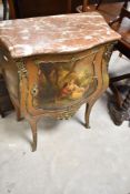 A Continental style wash stand or side cabinet of bombe form having rouge marble top and gilt