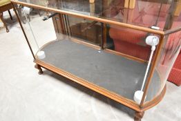 A vintage shop display cabinet being fully glazed including dome ends, having mahogany frame or