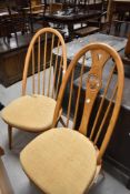 Two pairs of Ercol high back dining chairs, one pair having hoop and stick back, the other having