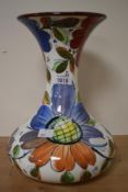 A vintage Spanish Pottery and Roma vase, decorated with colourful foliage on a white ground,