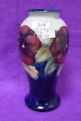 A William Moorcroft Pottery Pansy pattern baluster vase, tube-lined with flowers against a washed
