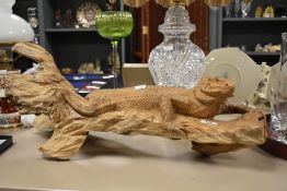 A large table top carved wood sculpture of a bearded dragon in a seated position, L72cm.