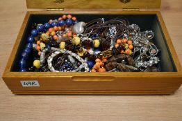 A wooden jewellery box, having a stained glass floral lid containing a collection of costume
