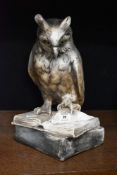A 20th century lifelike plaster cast sculpture of an owl displayed perched thoughtfully on an open