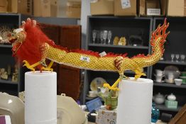 A Chinese fire dragon puppet, having brightly coloured paper and cloth carnival style dress, L60cm