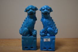 A pair of early 20th century ceramic Dogs of Foo, painted in a rich turquoise/blue glaze, one has an