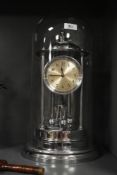 A large chrome plated 400 day anniversary clock, under glass dome with torsion pendulum 43cm