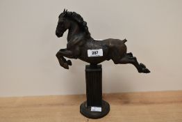 A mid-century North light resin horse sculpture, supported on a rectangular fluted column, makers