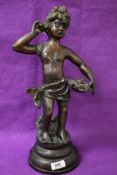 A heavy 19th century style cast metal figure of a girl with a gathering basket, supported on a three