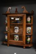 A vintage table top glazed display cabinet holding a selection of Cloisonne oriental cups, decorated
