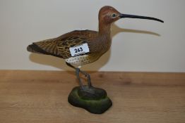 A vintage hand carved wooden study of an Eskimo curlew, displayed standing on a rock, hand coloured,