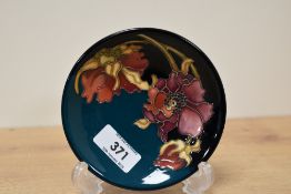 A Moorcroft Pottery Orchid pattern pin dish, of circular form and tube-lined with blossoms, printed,