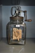 A large vintage blown glass butter churn, having pine handle and impressed manufacturing marks to