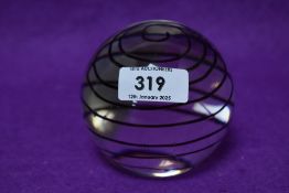 A modern glass paperweight, of spherical form with spiral decoration 8cm
